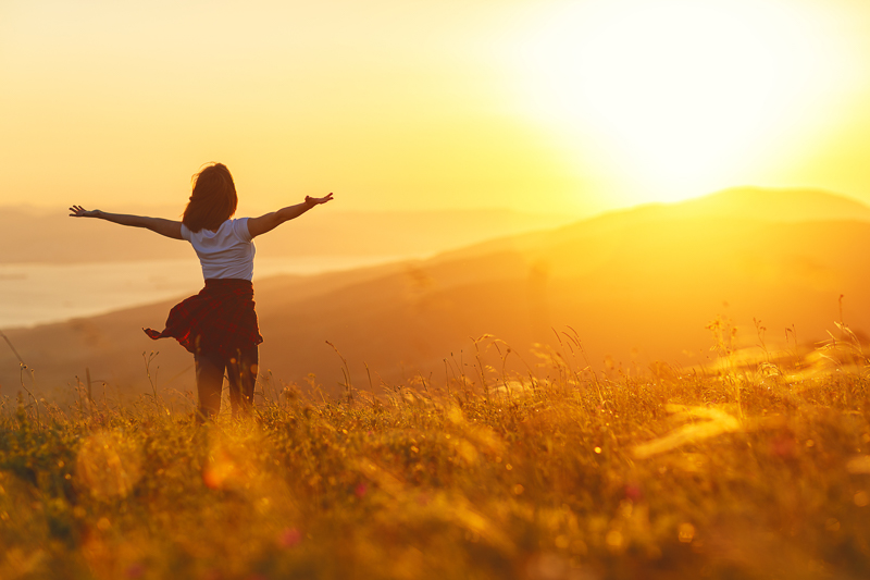 Frau beim Sonnenaufgang